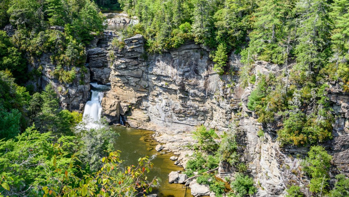 Aerial view of Linville Falls surrounding by rocks, cliffs and green trees during daytime