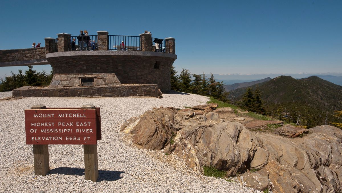 Peak of Mount Mitchell with lookout tower and sign on sunny day
