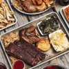 Overhead shot of plates of barbecue and sides on table