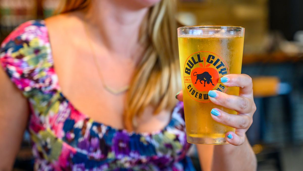 Girl holding pint of cider at Bull City Ciderworks