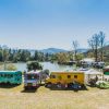 Colorful trucks parked by lake at LEAF Festival in Black Mountain on sunny day 