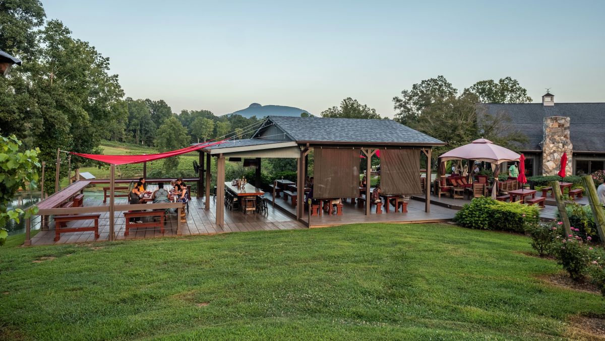Outdoor dining area at winery with Pilot Mountain in background