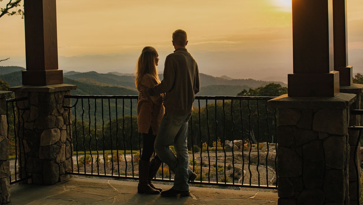 Couple standing on outdoor patio looking off into mountains