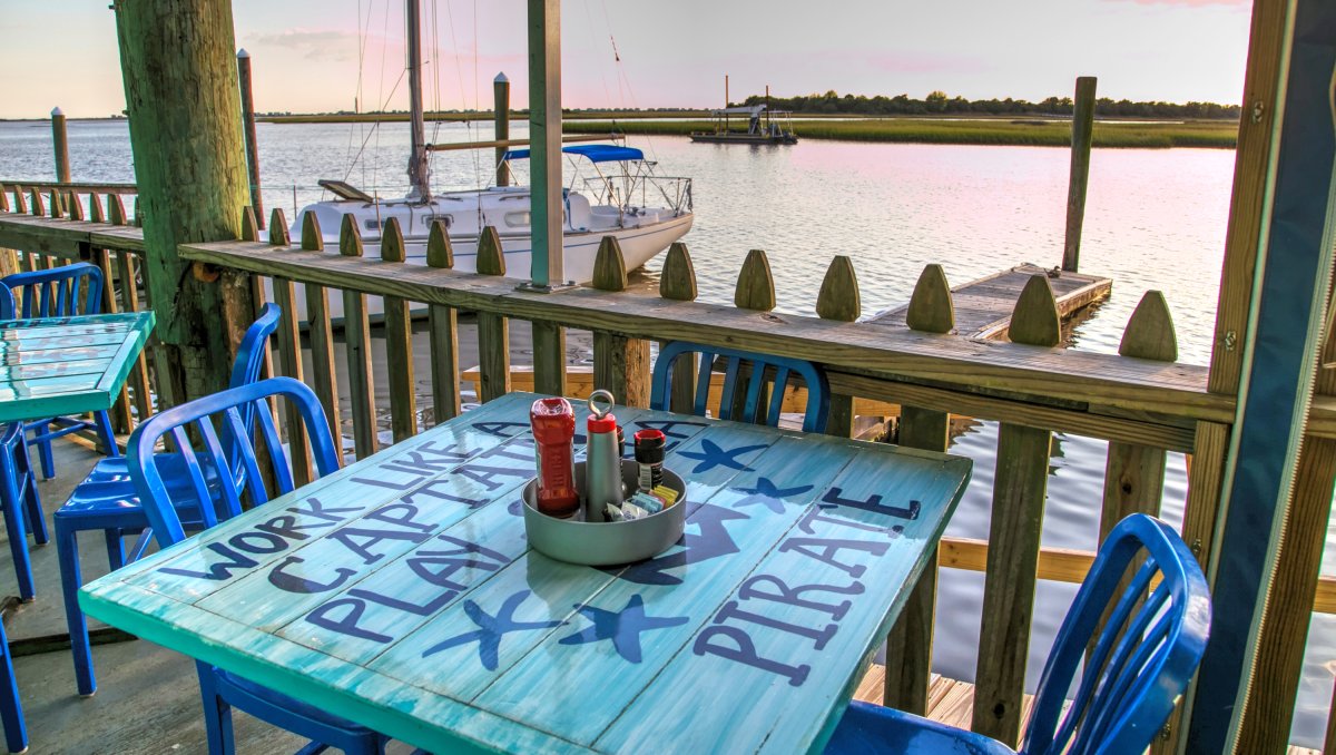 Blue table and chairs on restaurant dock that overlooks water