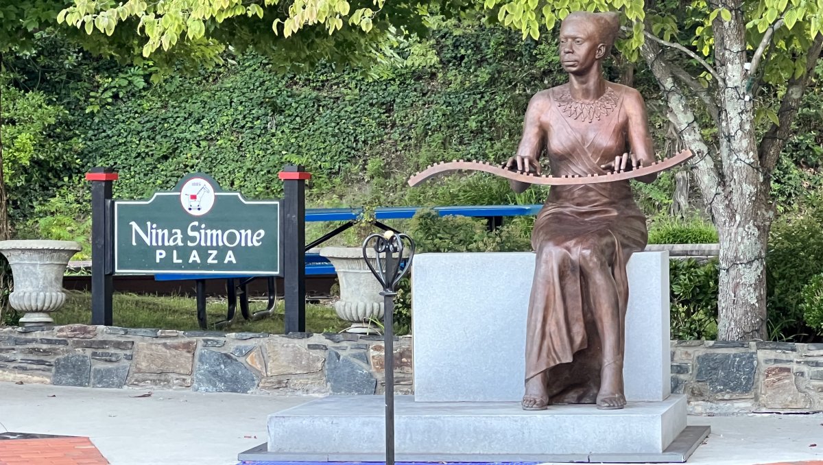 Bronze statue of Nina Simone next to sign reading 
