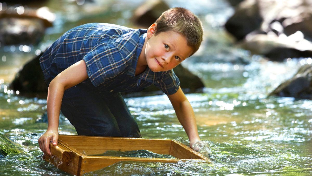 Young boy searches for gems in river