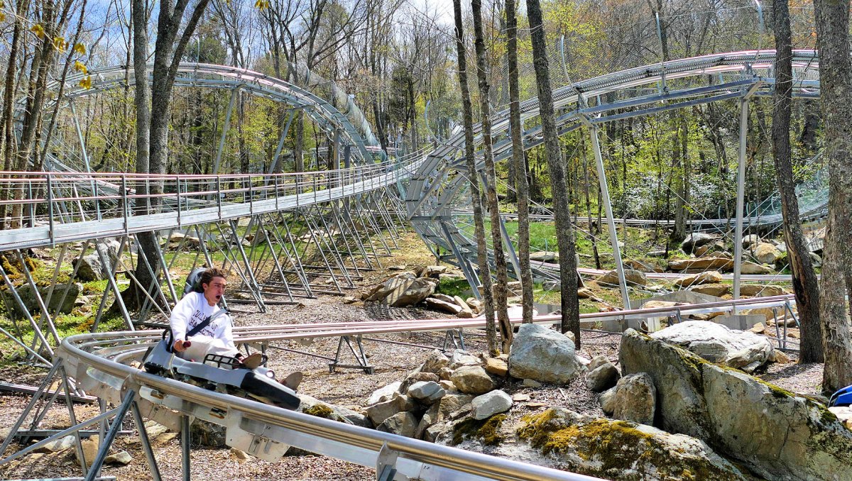 Person riding alpine coaster down with rest of track in background