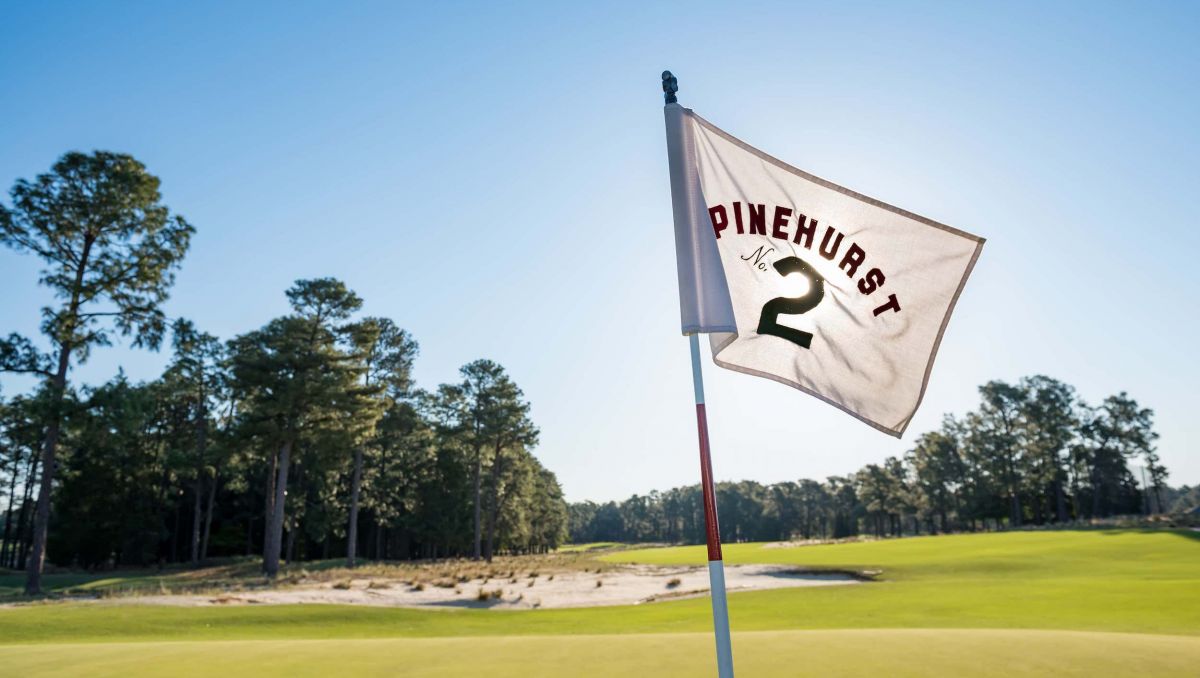 Pinehurst No. 2 flag with course in background on sunny day