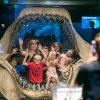 Woman taking photo of family standing in shark's mouth at aquarium