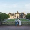 Family of 3 standing at stone wall overlooking Biltmore Estate and grounds