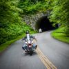 Motorcyclists coming out of tunnel on Blue Ridge Parkway near Maggie Valley surrounded by green trees