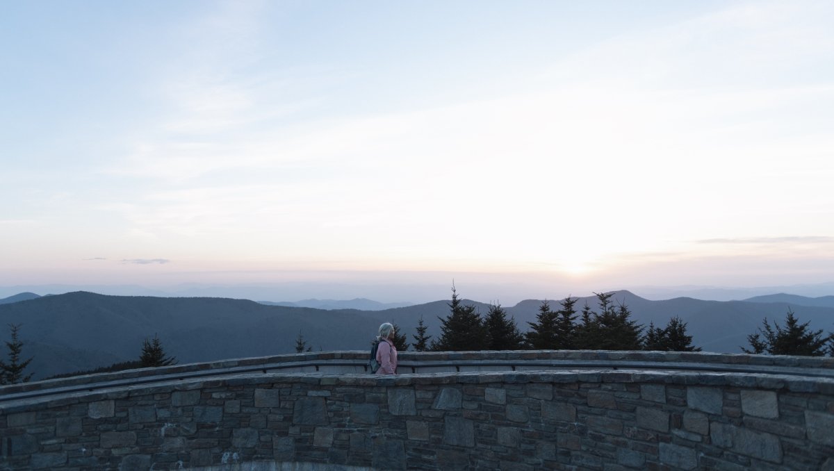 Person walking on ramp up to summit at Mount Mitchell with mountains in background