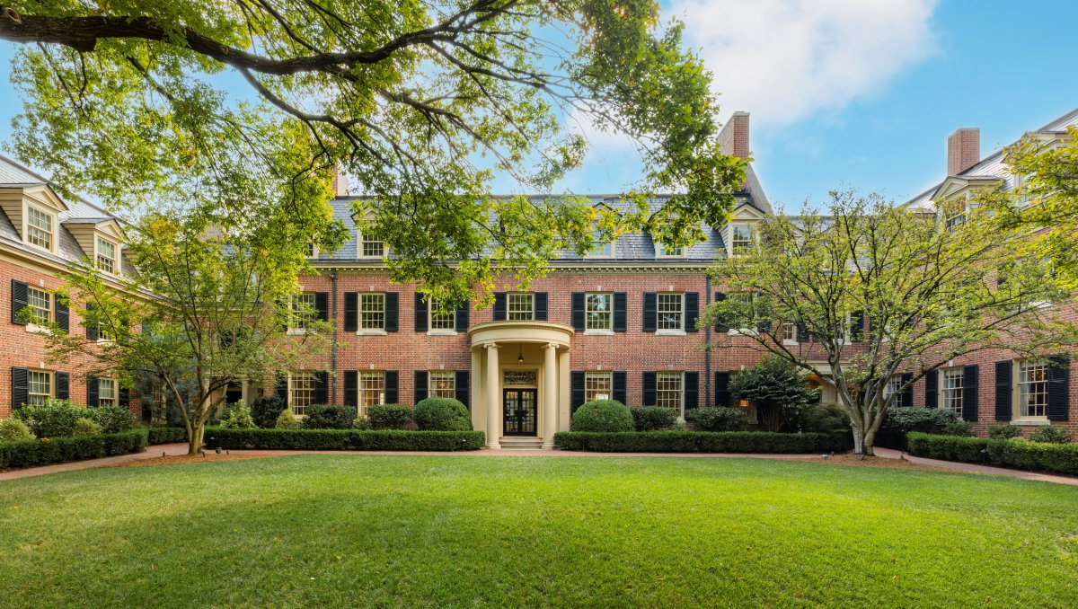 Exterior of brick Carolina Inn with charming courtyard in foreground