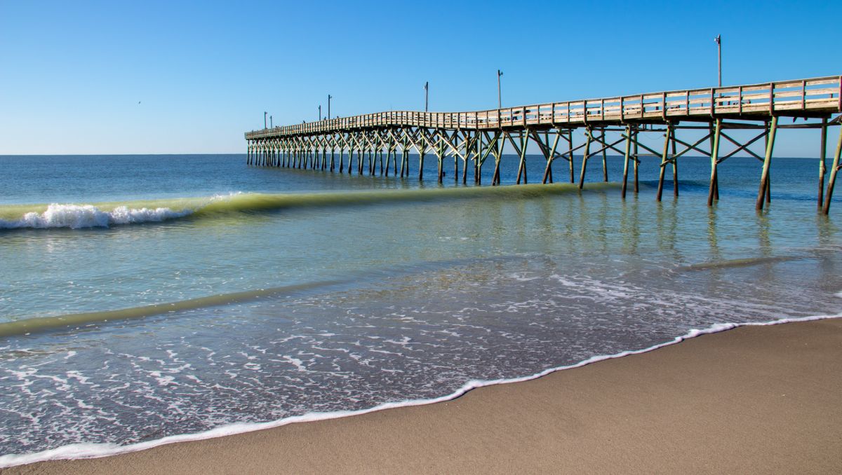 Holden Beach Pier jutting into water during daytime in Brunswick Islands