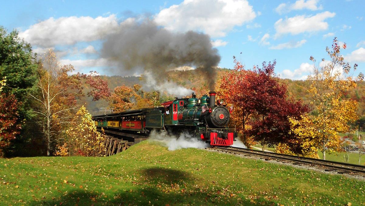 Tweetsie Railroad train in middle of fall foliage on train tracks