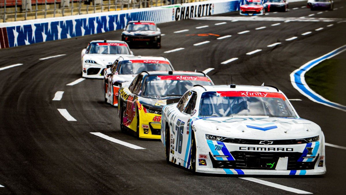 NASCAR cars racing on track at Charlotte Motor Speedway.