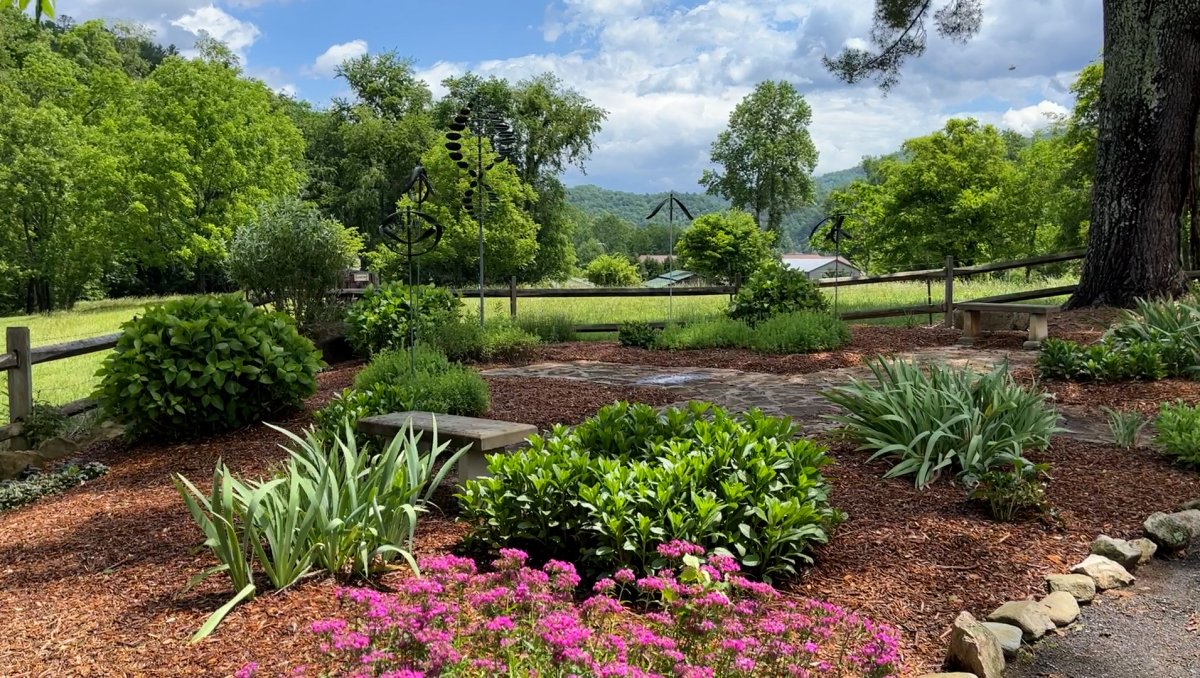 Beautiful garden at Stecoah Valley Center with field and mountains in distance.