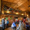 People enjoying beers inside at Appalachian Mountain Brewery, with hand-painted mural above bar