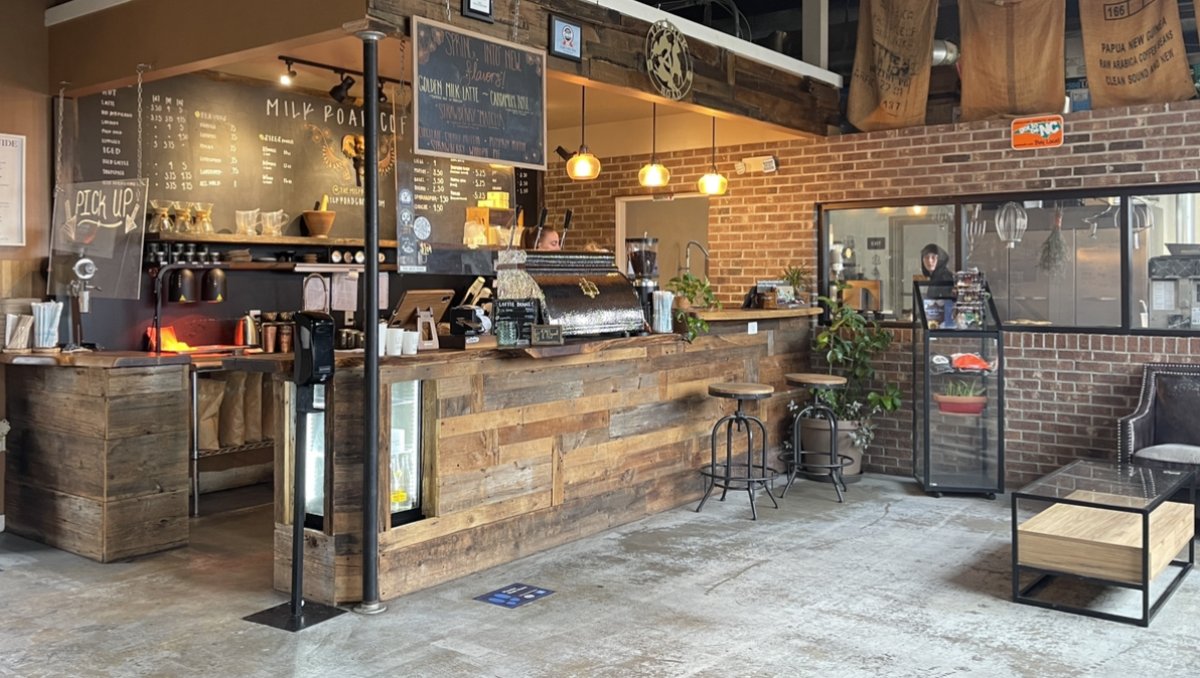Interior of coffee shop with handwritten signs and wood and brick accents