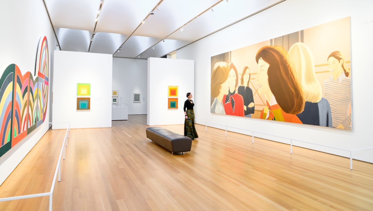 Woman standing in art gallery admiring art on walls