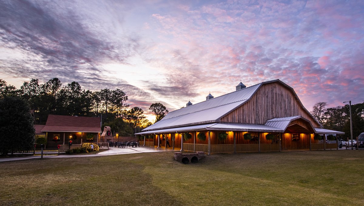 Overall view of Mike's Farm with patio to the left at dusk with purple and pink sky