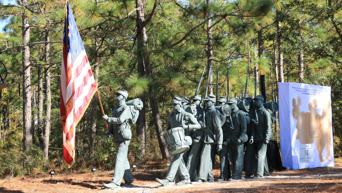 Lifesize statue of men in United States Colored Troops, outside with trees in background