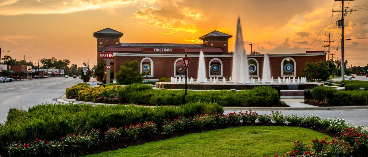 Gardens and Freedom Fountain in Jacksonville with brick bank and downtown in background and orange sky