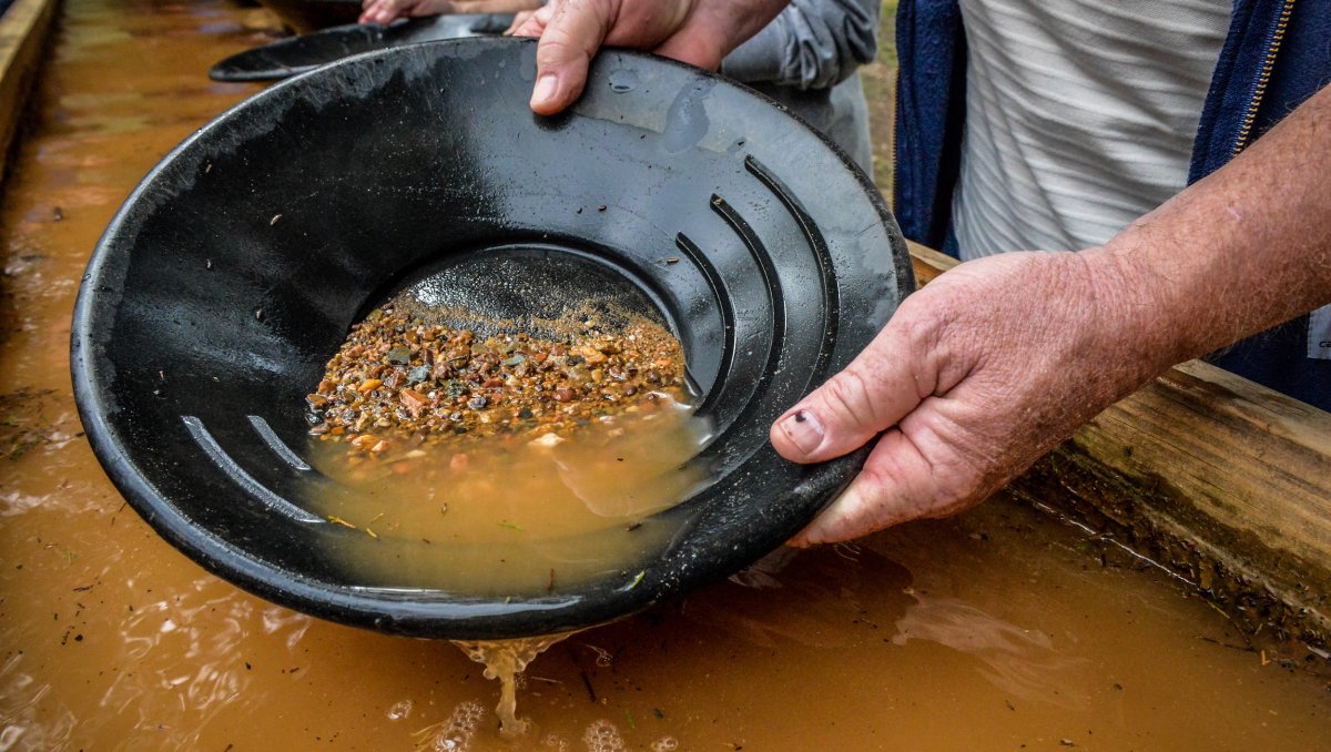 Close-up of hands panning for gold in a gold mine