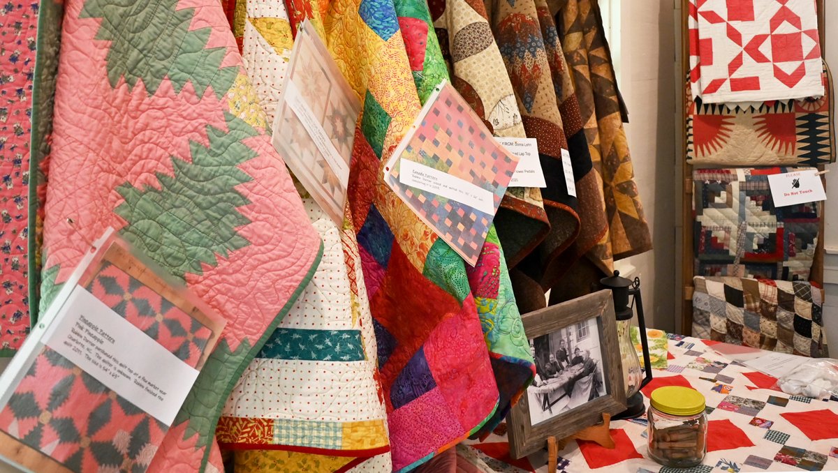 Closeup of quilt vendor with different fabrics on display.