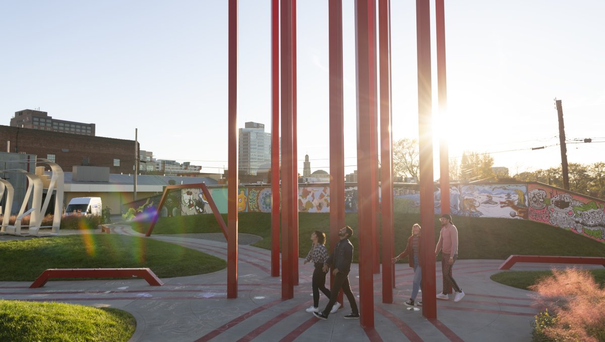 Four friends walking through art park in Winston-Salem