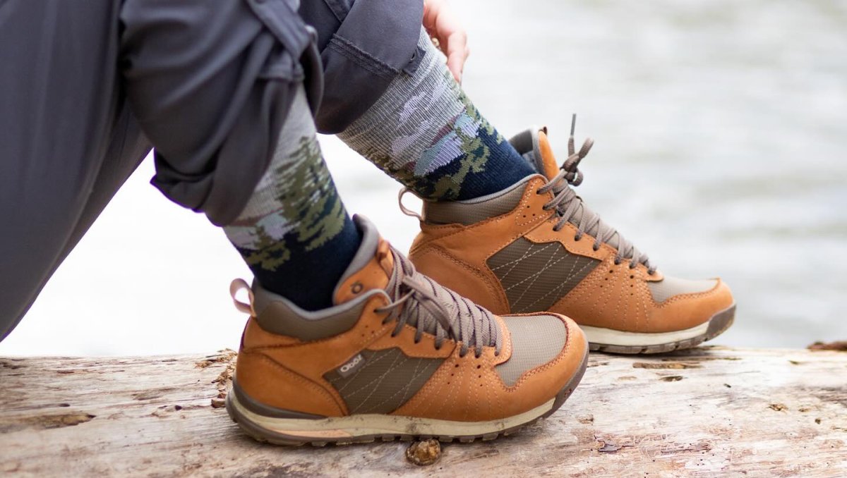 A person in hiking shoes takes a break on a log, surrounded by the beauty of the great outdoors.