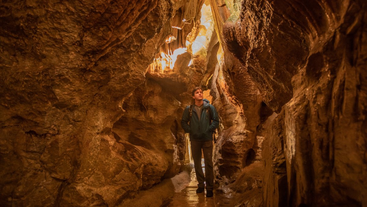 Man walking in brightly lit cavern
