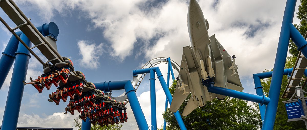 Large blue roller coaster with spaceship at Carowinds amusement park outside.