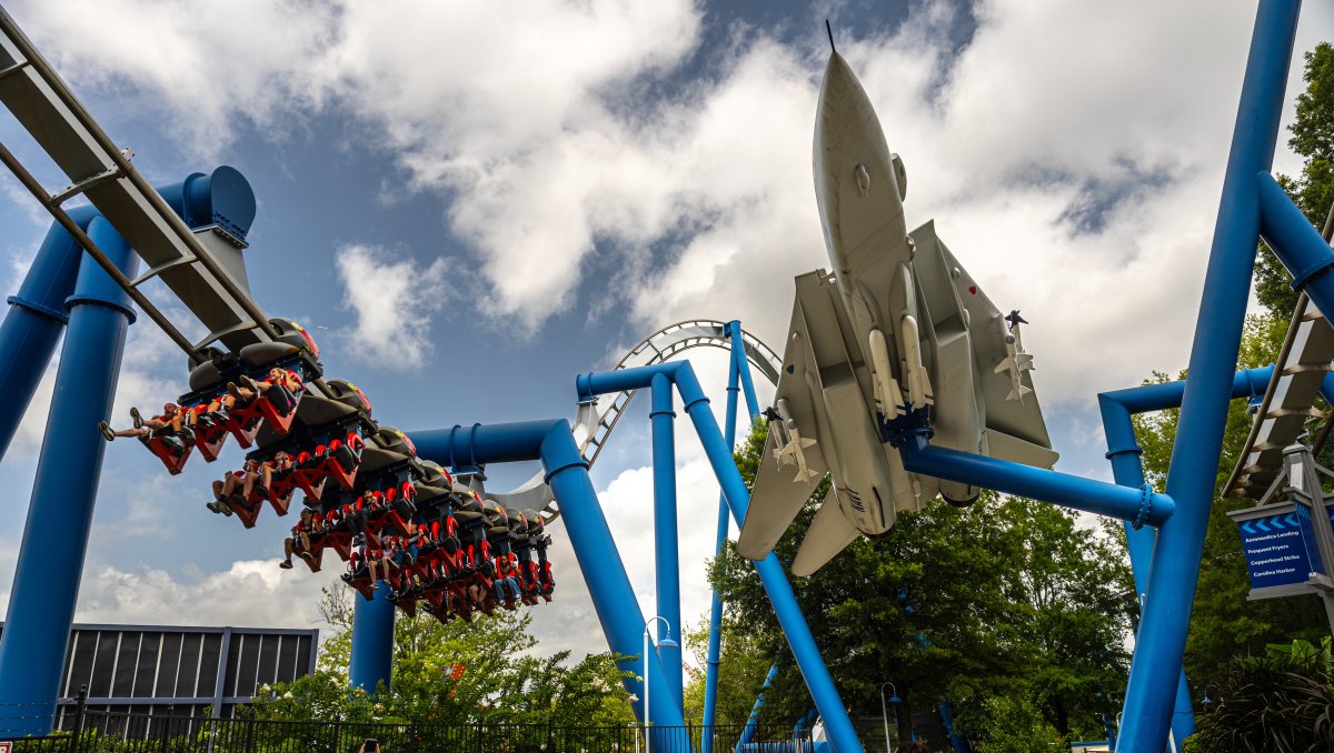 Large blue roller coaster with spaceship at Carowinds amusement park outside.