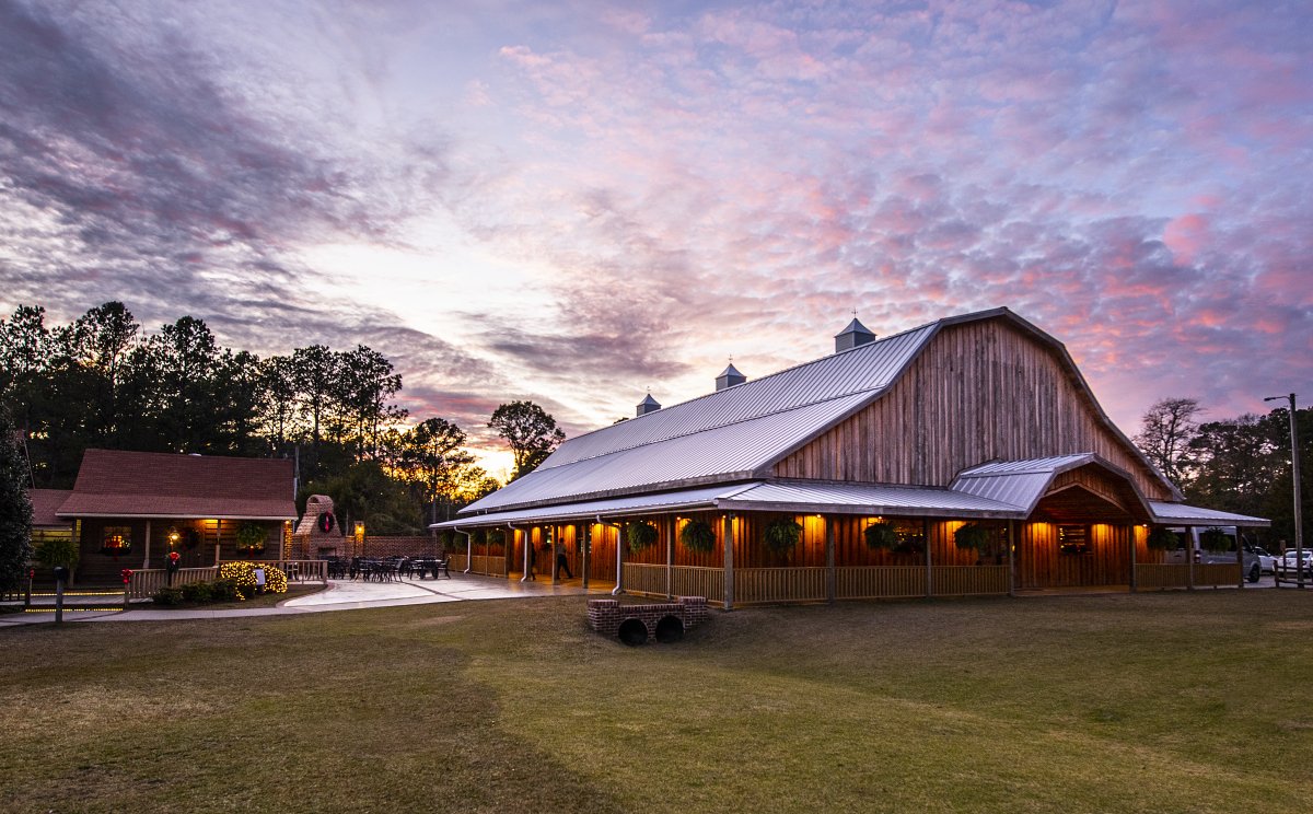 Exterior of farm and patio beneath purple and pink sky