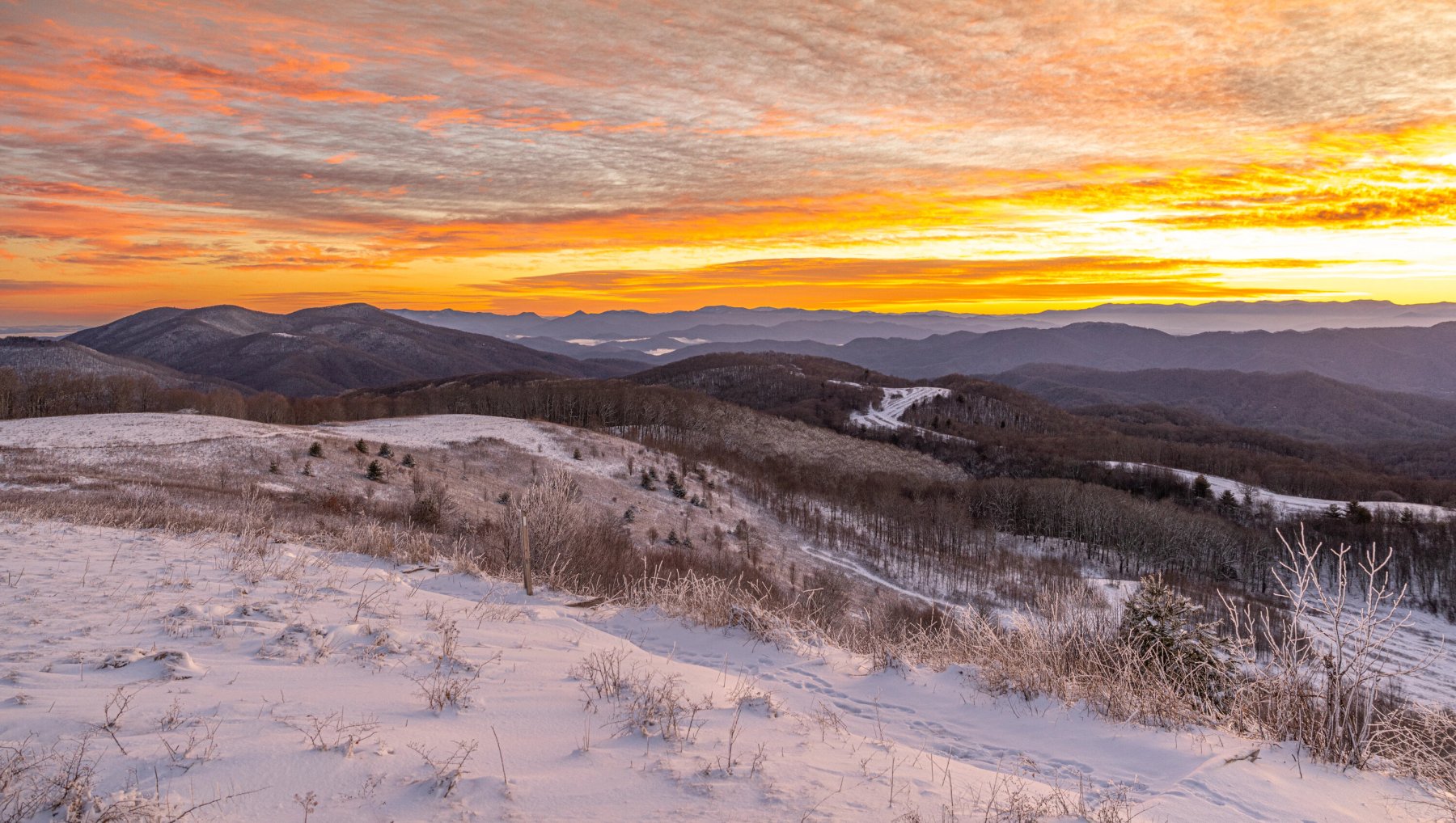 Long-range views of snowy mountains and landscapes under sunrise.