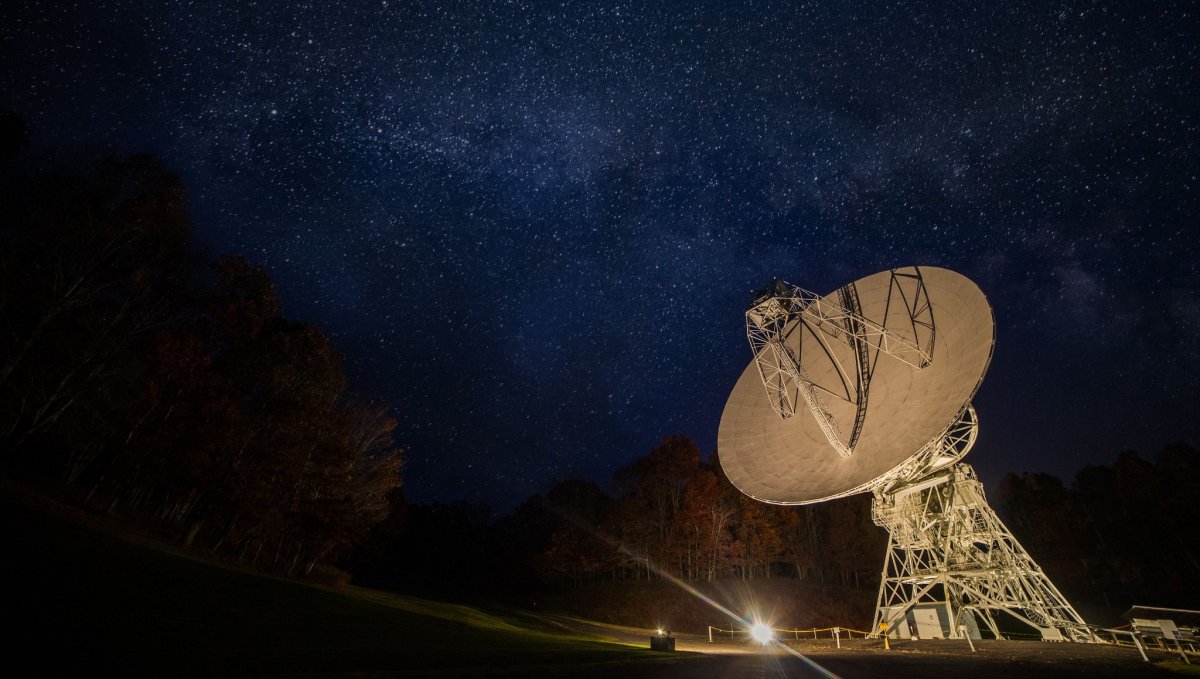 Large satellite lit up at night with starry sky above