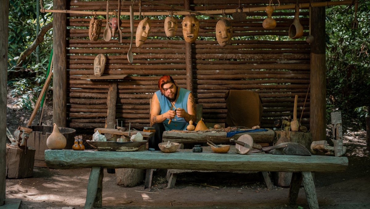 Person working on hand-crafted art in Oconaluftee Indian Village.