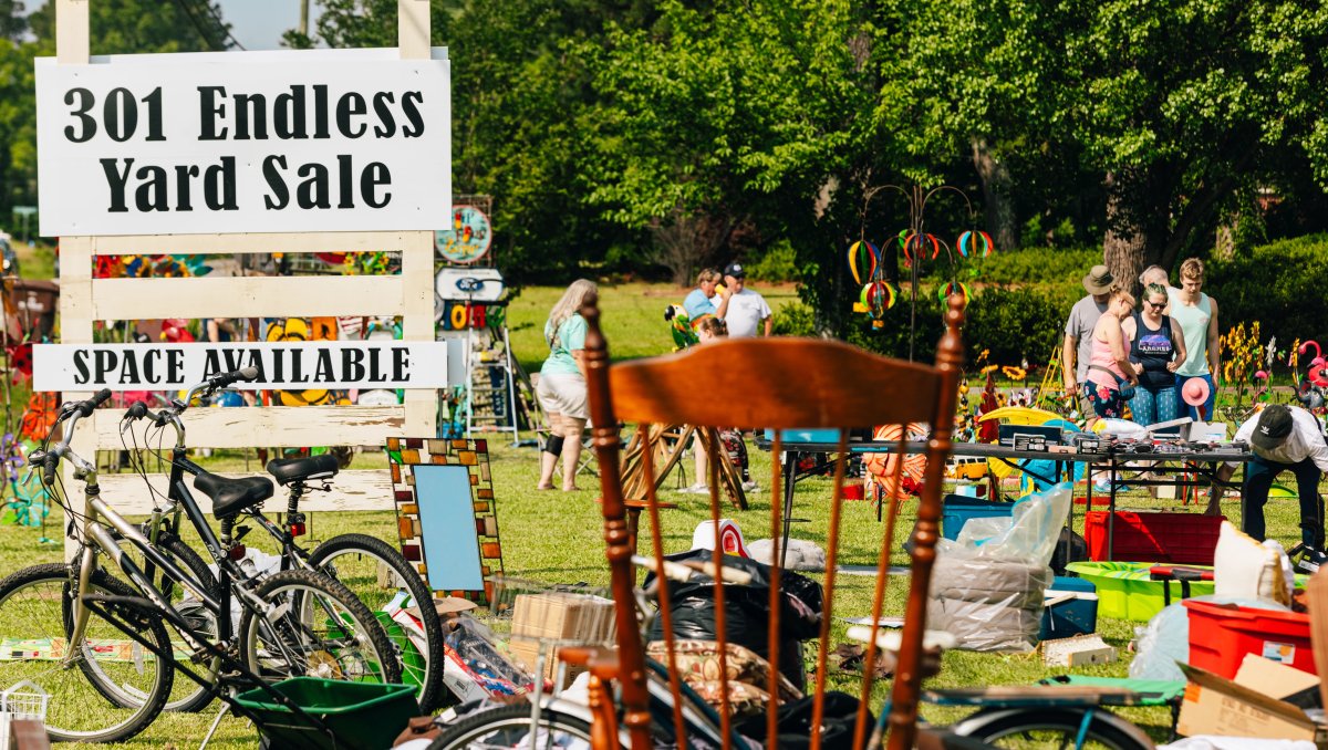 People shopping at outdoor 301 Yard Sale with signage in foreground