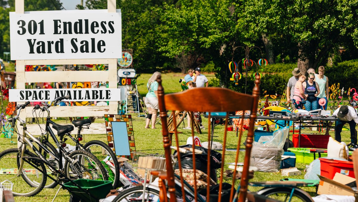 People shopping at outdoor 301 Yard Sale with signage in foreground