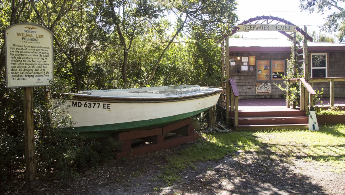 Exterior of Deepwater Theater with boat and sign by entrance