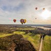 Colorful hot air balloons in sky over fall landscape