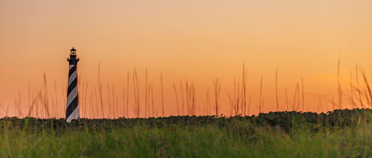 Cape Hatteras Lighthouse and surrounding landscape at sunset