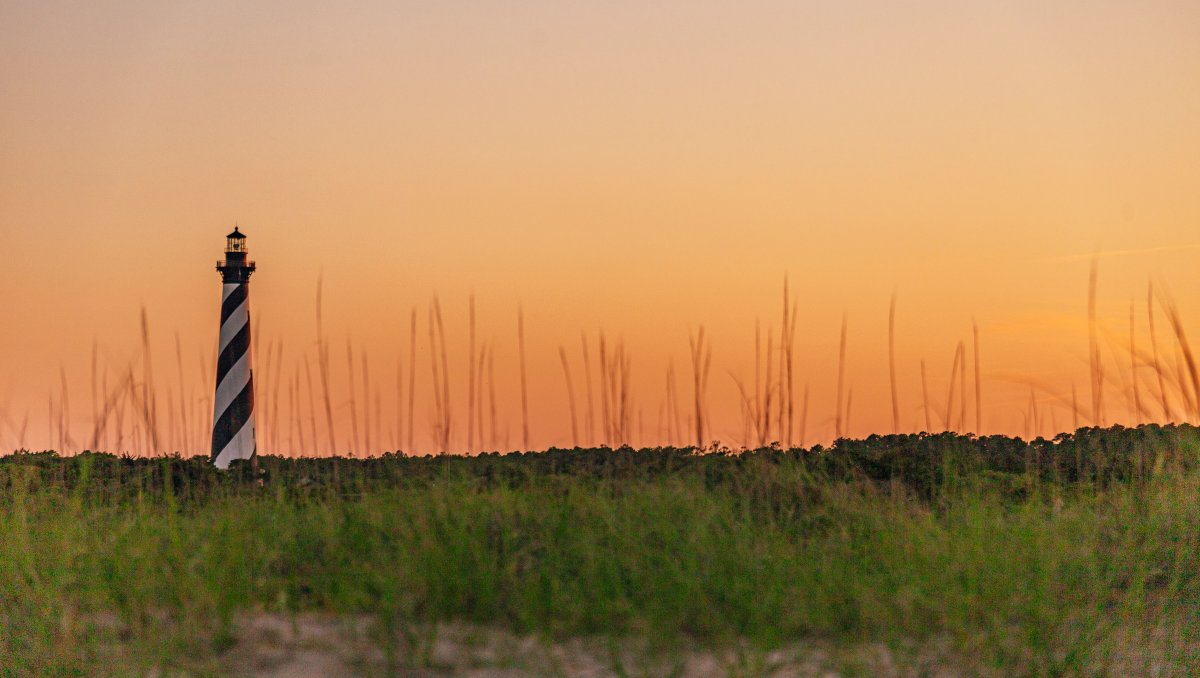 Cape Hatteras Lighthouse and surrounding landscape at sunset