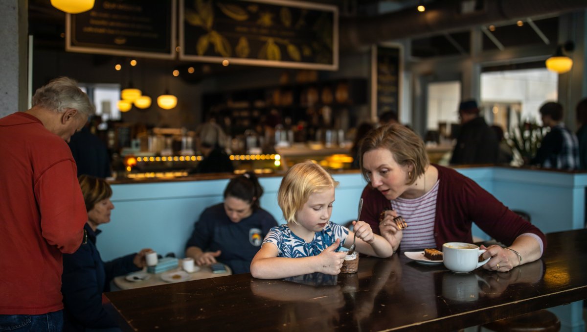 Mother and daughter enjoying chocolate treats sitting at a table