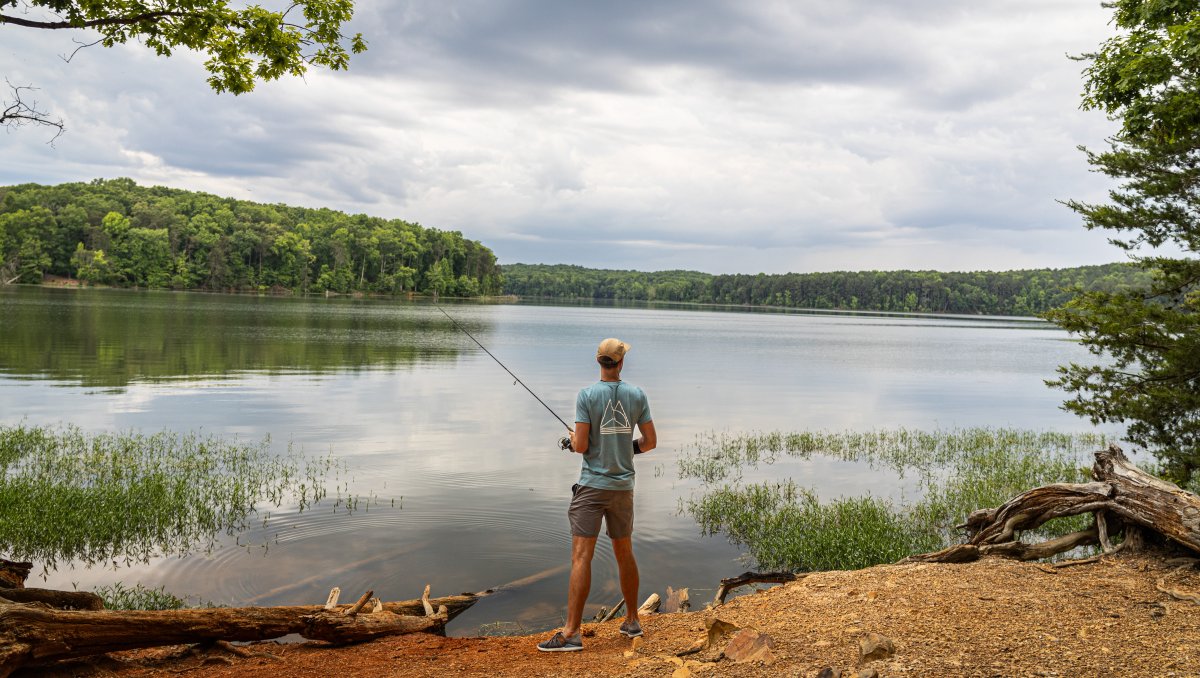 Man fishing and gazing out over Badin Lake in Uwharrie National Forest, North Carolina.