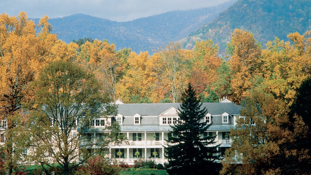 Grand inn surrounded by fall foliage trees with Great Smoky Mountains in background