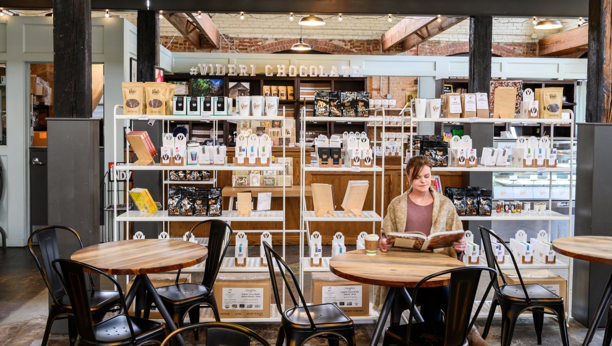 Woman Sitting and Reading at Table in Videri Chocolate Factory in Raleigh.