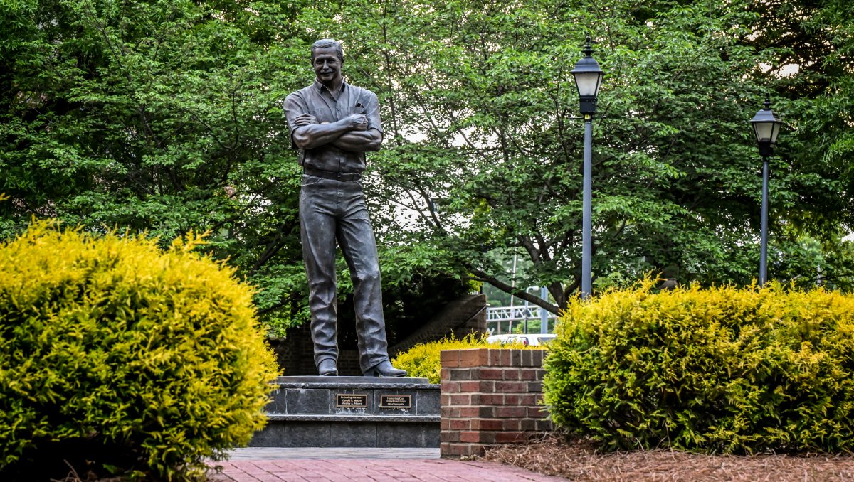 Dale Earnhardt statue at Dale Earnhardt Tribute Plaza surrounded by trees.