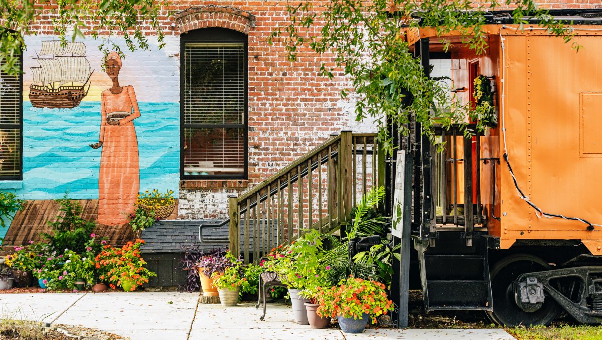 Exterior of Underground Railroad Museum with plants on ground and mural on wall